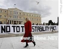 Protesters hold a banner reading 'No to the Stability Pact' in front of the Greek Parliament in Athens on Thursday